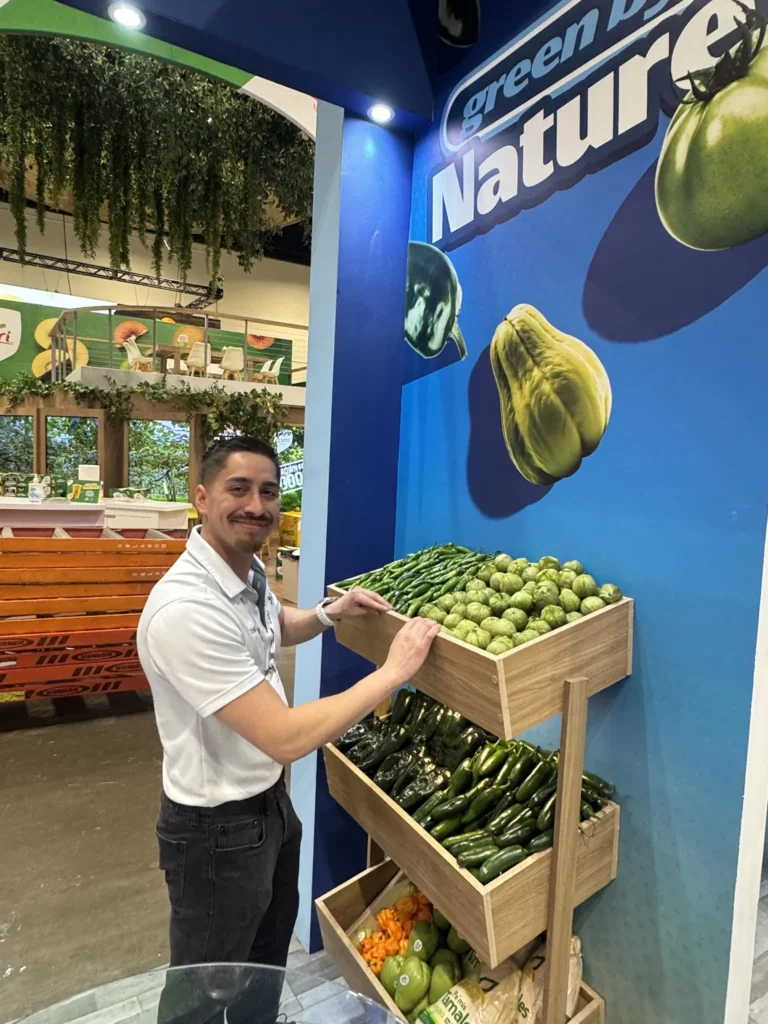 SiCar Farms team member arranging produce at the booth